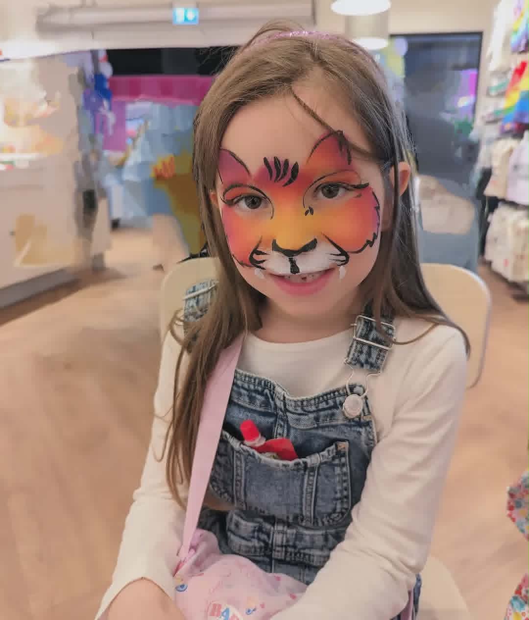 Eventyrlig tigeransiktsmaling i oransje og gult med detaljerte striper