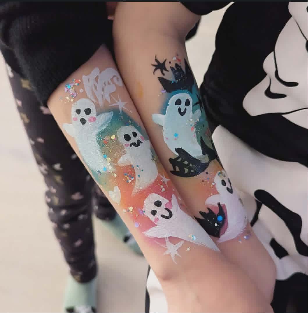 Søte halloween-spøkelser malt på armer med fargerik glitter